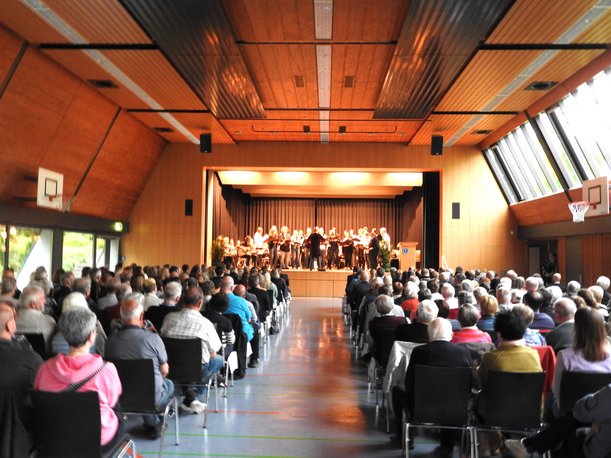 Gut besuchte Gemeindehalle, musikalische Umrahmung durch Musikverein und Chor Taktgefühl